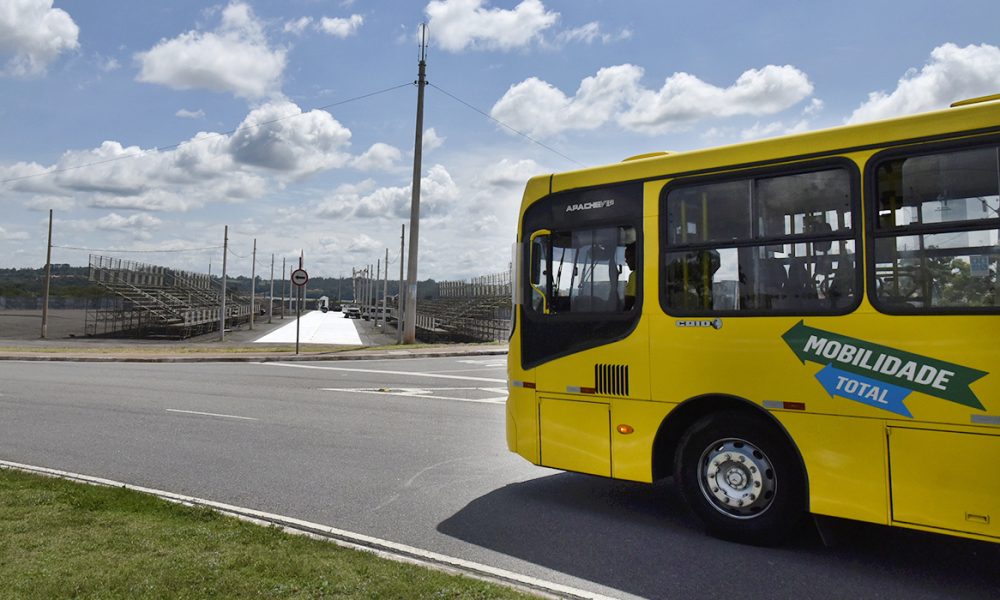 ônibus amarelo trafegando em rua
