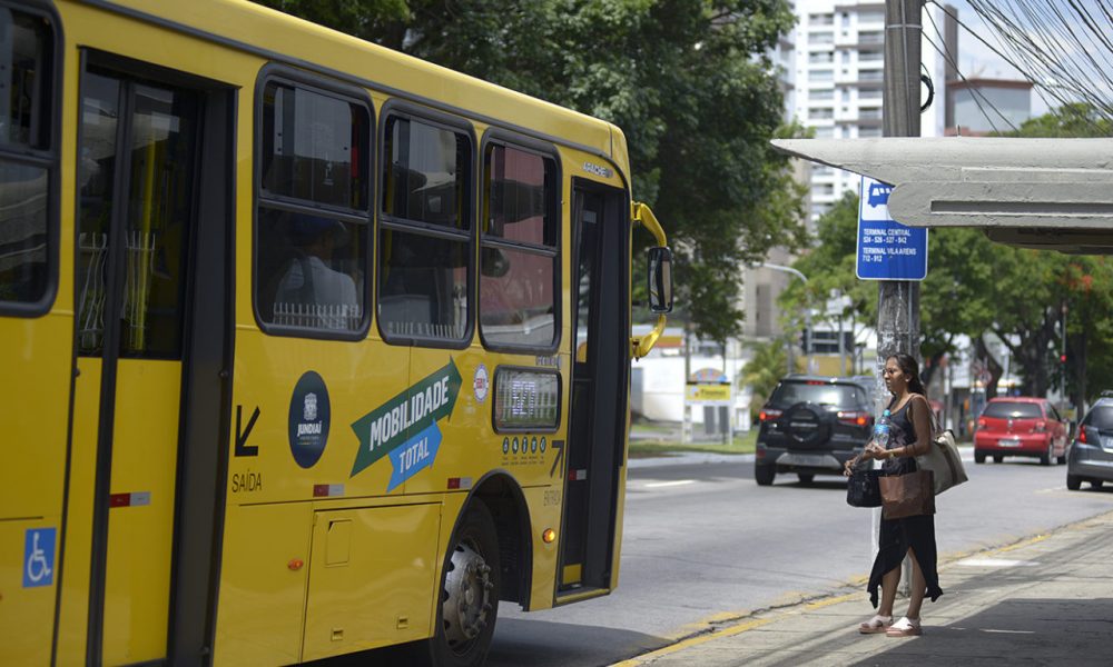 onibus parado no ponto para perto de uma mulher