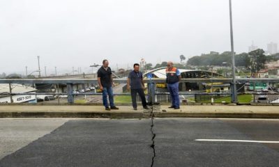 Homens sobre viaduto com rachadura no asfalto