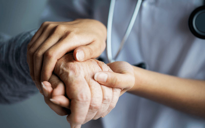 Enfermeira segura mão de pessoa idosa
