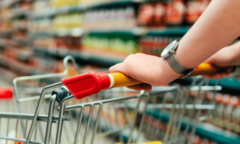 Consumidor segura barra de carrinho de supermercado