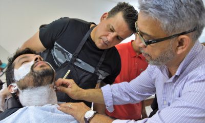 homem cortando a barba de um cliente