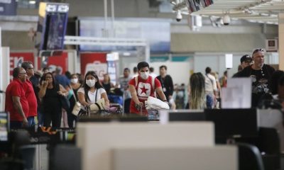 Foto de pessoas com máscaras em aeroporto