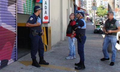 Foto de agentes na frente de estabelecimento