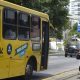 Ônibus estacionado em ponto, com mulher na porta