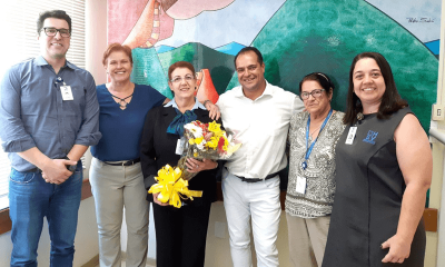 Selma Moraes, ao centro, com buquê de flores; ao lado dela, representantes do Sindicato da Saúde; funcionários do Hospital São Vicente e superintendente.