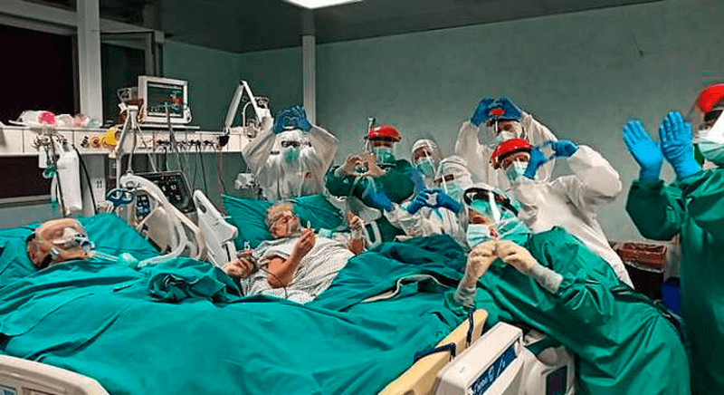Médicos e enfermeiros fazem corações com as mãos ao lado dos leitos da CTI