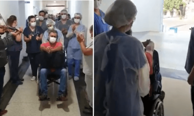 Colaboradores aplaudem médico enquanto ele deixa o hospital na cadeira de rodas