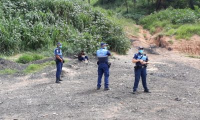 Foto de homem em área de mato com guardas municipais