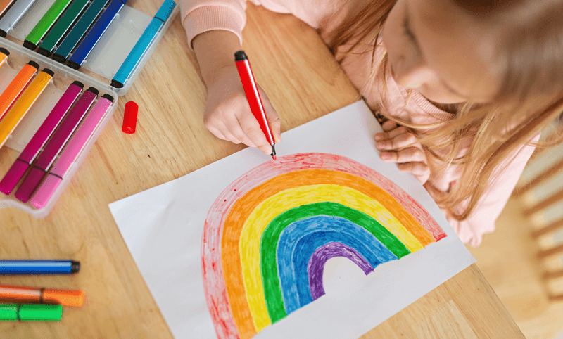 Criança desenha arco-íris