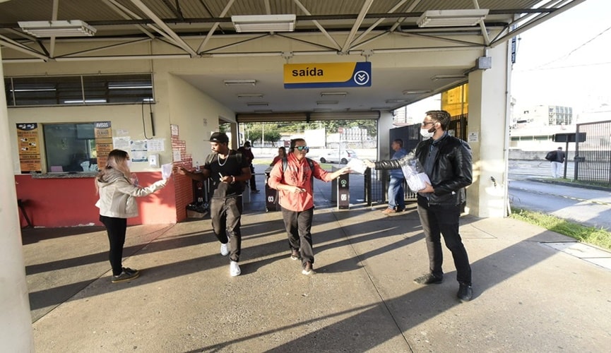 Foto de pessoas entregando máscaras à população