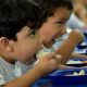 Crianças comendo merenda escolar