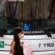 Foto de mulher atravessando de máscara na frente de ônibus