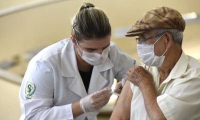 enfermeira aplicando dose de vacina em idoso