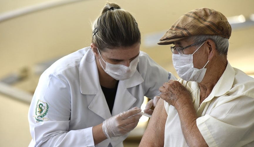 enfermeira aplicando dose de vacina em idoso