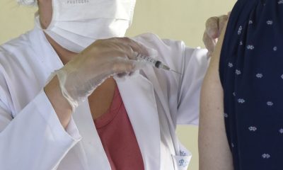 Foto de enfermeira aplicando vacina em idosa