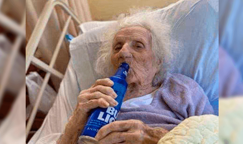 Idosa bebendo cerveja em cama hospitalar