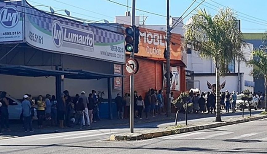 Foto de fila de pessoas em agência bancária