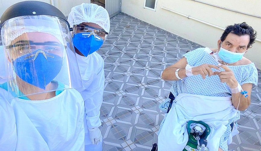 Foto de paciente e equipe médica durante banho de sol em hospital
