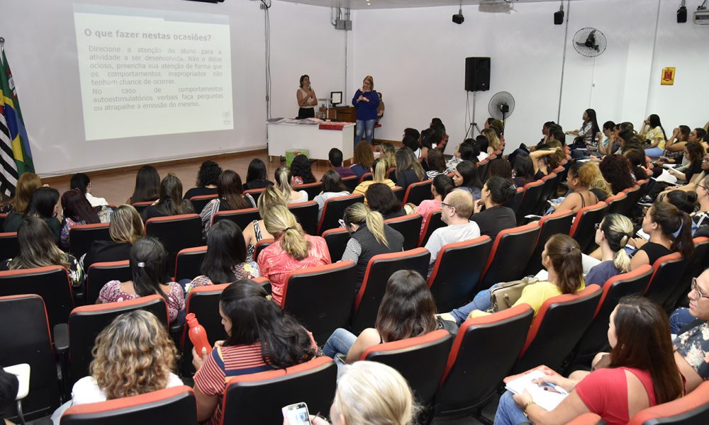 Professores acompanham palestra em auditório