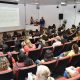 Professores acompanham palestra em auditório