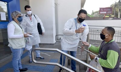 Foto de pessoas distribuindo máscaras de proteção