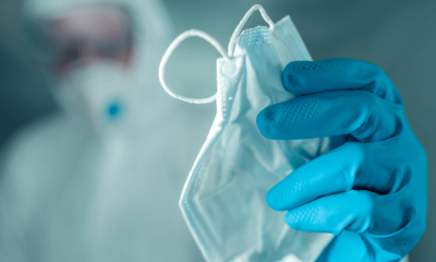 Médico segura máscara cirúrgica nas mãos com luvas