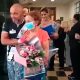 Foto de idosa com buquê de flores na saída de hospital
