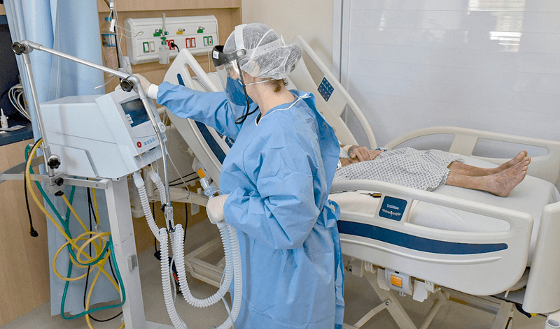 Enfermeira ajusta equipamentos de paciente com coronavírus