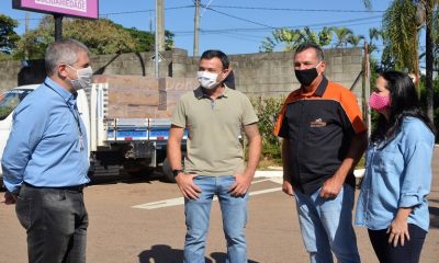 grupo de pessoas em frente de caminhão com cestas básicas