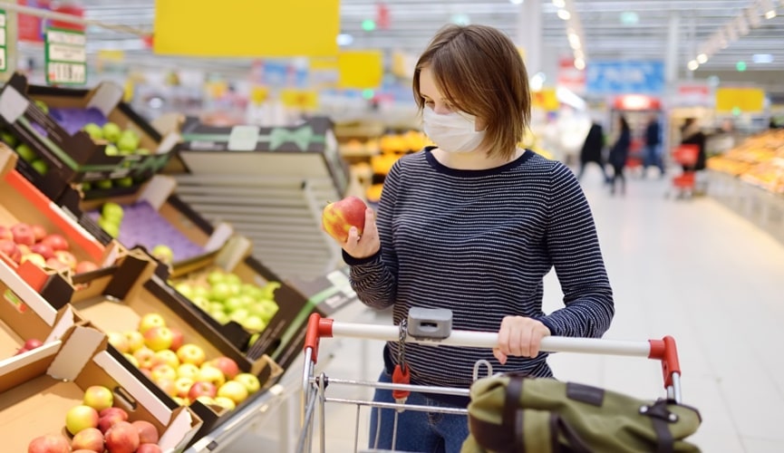 Foto de mulher escolhendo maçã em supermercado
