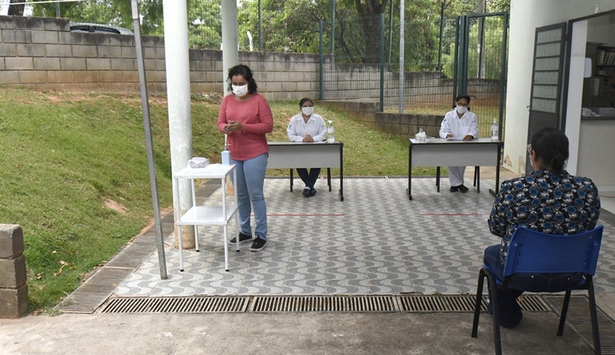 Foto de mulher passando álcool em gel na mão em recepção hospitalar