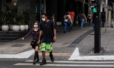 Foto de casal atravessando avenida