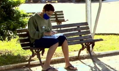 Foto de menino estudando em praça