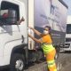 Funcionária da CCR AutoBAn entrega álcool a caminhoneiro