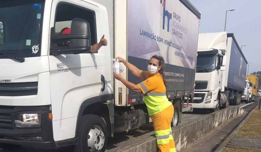 Funcionária da CCR AutoBAn entrega álcool a caminhoneiro