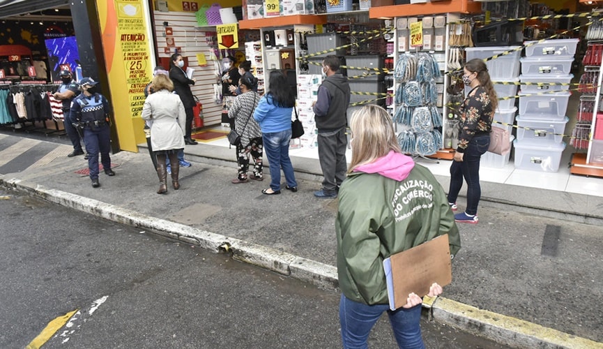 Foto de comércio central aberto com fiscalização na porta