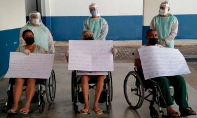 Família segurando cartazes na saída do Hospital