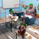 Crianças em sala de aula separadas por barreira de acrílico