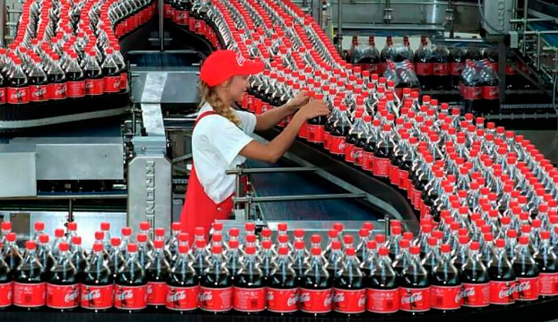 Funcionária trabalhando em linha de produção da Coca-Cola