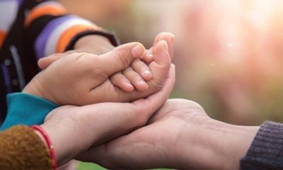 Pessoas segurando mãos de crianças