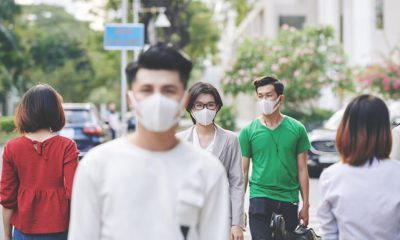 Pessoas andando na rua com máscaras