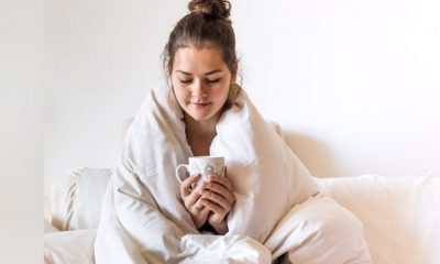 Foto de mulher com coberta e café na mão