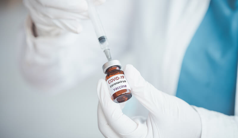 Profissional da saúde usa seringa para pegar vacina de frasco
