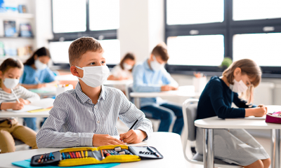 Alunos em sala de aula, usando máscaras de proteção