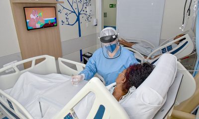 Enfermeira cuidando de paciente em quarto hospitalar