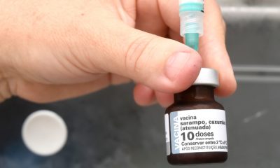 Mão segurando vacina contra sarampo