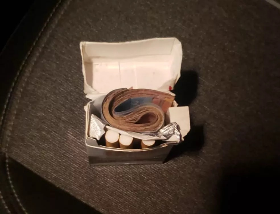Caixa de cigarros com dinheiro esquecido em carro de aplicativo.