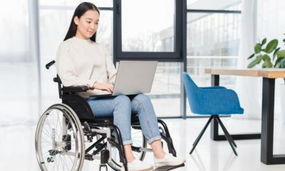 Mulher em cadeira de rodas com computador no colo