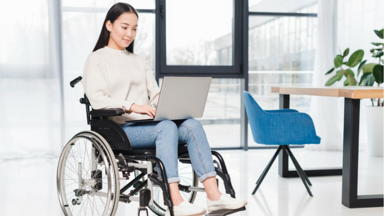 Mulher em cadeira de rodas com computador no colo